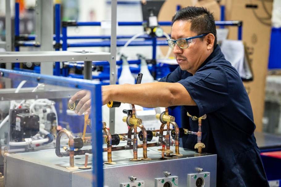 Marmon Renew technician calibrating equipment on a copper-plumbed test rig